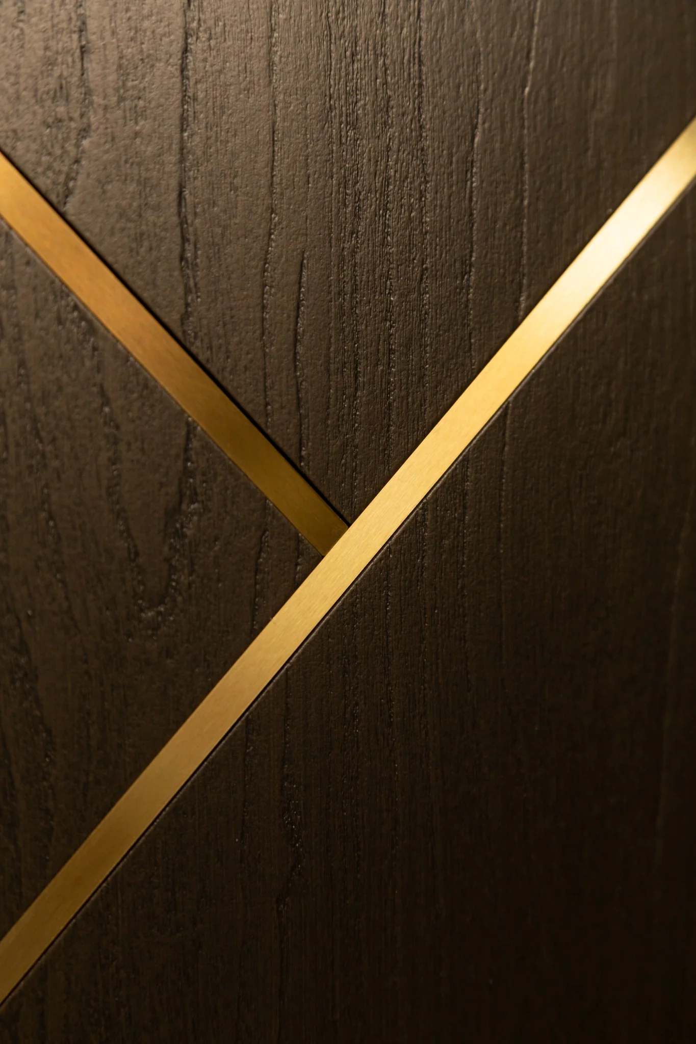 Close-up of brown woodgrain door with diagonal metallic inlays