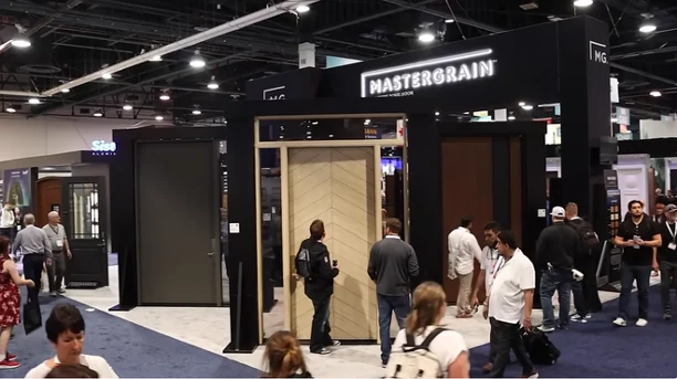 MASTERGRAIN trade-show stand with illuminated brand signage and natural woodgrain doors